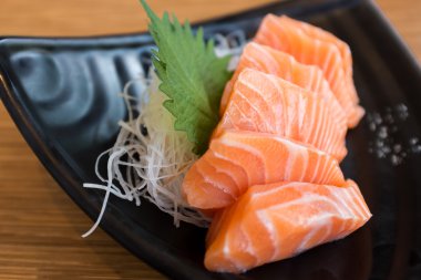 Siyah seramik plaka üzerinde somon balığı