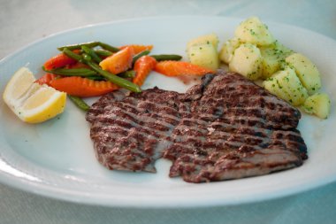 Bir fincan haşlanmış sebze ve limon ile dövülmüş biftek