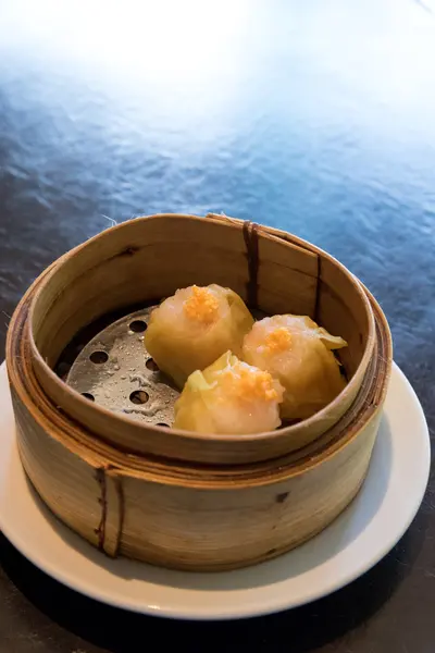Dim sum steamed prawn dumpling with fish roe under incandescent light — Stock Photo, Image