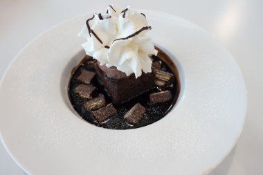 Çikolatalı kek ve dondurmayla kırbaç krem üzerine çikolata sosu ve gofret