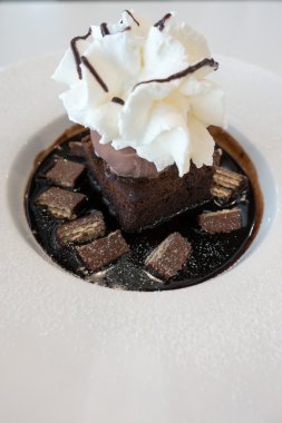 Çikolatalı kek ve dondurmayla kırbaç krem üzerine çikolata sosu ve gofret