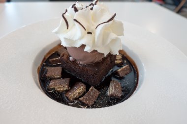 Çikolatalı kek ve dondurmayla kırbaç krem üzerine çikolata sosu ve gofret