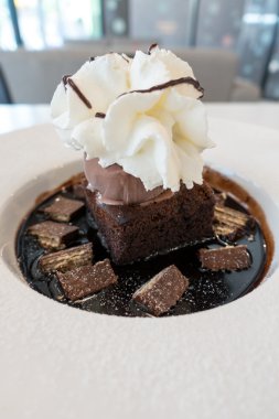 Çikolatalı kek ve dondurmayla kırbaç krem üzerine çikolata sosu ve gofret