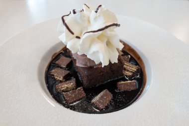 Çikolatalı kek ve dondurmayla kırbaç krem üzerine çikolata sosu ve gofret