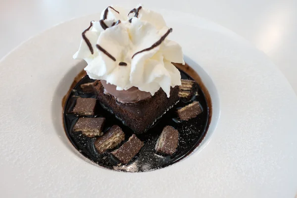 Chocolate fudge cake and ice cream on chocolate sauce and wafer with whip cream on top — Stock Photo, Image