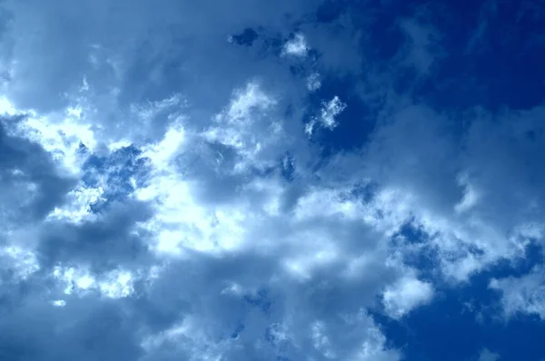 Mavi gökyüzüne karşı beyaz kümülüs bulutları. Güzel hava ve güneş.