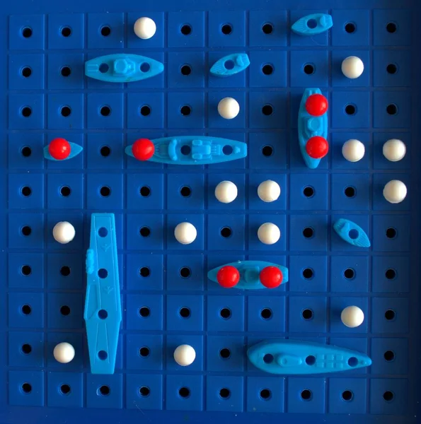 Çocuk oyunu deniz savaşı. Mavi alan ve mavi gemiler. Devam eden bir savaş var. Ölü gemiler. Savaş alanı.