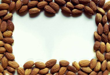 Badem fıstıkları bej arka planda çerçevelenir. Dekorasyon için badem