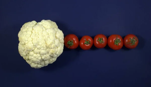 Brokoli üst manzara ve kırmızı domatesler bir sırada. Mavi arka plan. Uygun beslenme