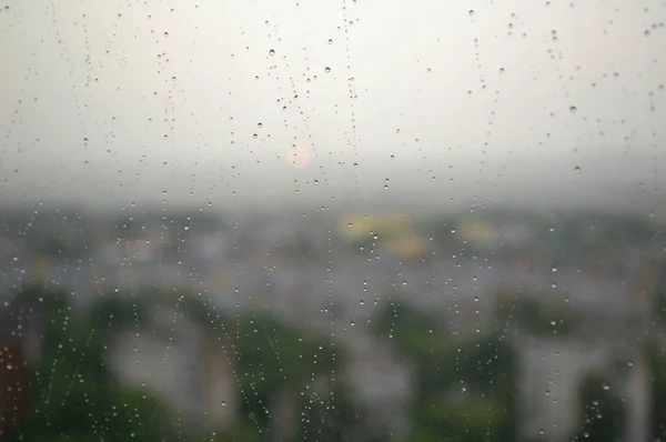 雨后雨滴在玻璃杯上 落在城市的背景上 — 图库照片