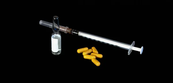 注射用アンプル 黄色の錠剤カプセルと黒の背景に注射器 — ストック写真