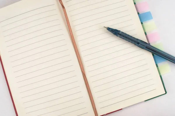 Renkli yer imlerine ve beyaz arkaplanda bir kaleme sahip açık bir defter