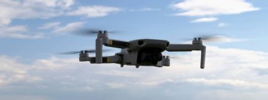Mavi gökyüzü ve beyaz bulutların arka planında uçan bir dron..