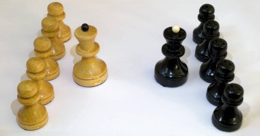 Beyaz arka planda satranç taşları. Karşıdaki ilk satırda vezir, arkalarında da piyon var.