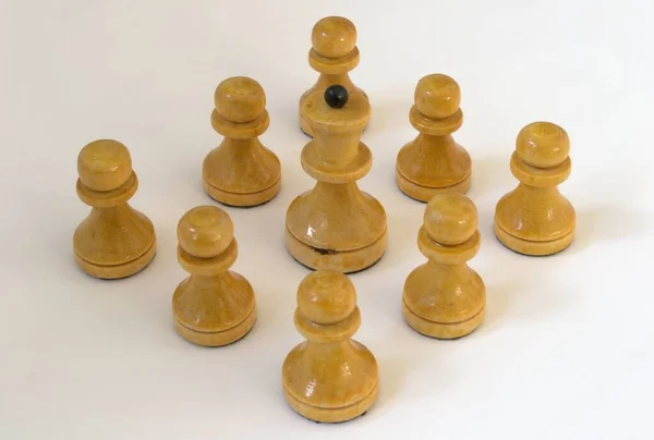 Beyaz arka planda beyaz piyonlarla çevrili beyaz bir vezir. Satranç taşları.