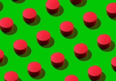 Tasarım ve afiş için arka plan. Yeşil arka planda gölgesi olan küçük kırmızı bir silindir. Desen
