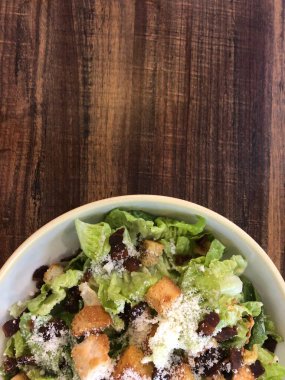 Yarım kase sade ahşap kaplamalı salata.