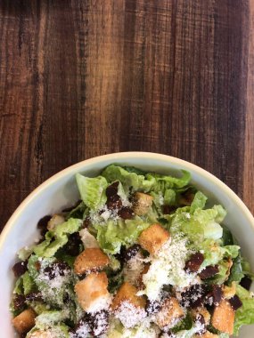 Yarım kase sade ahşap masa desenli salata.