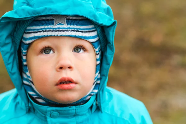 Un ragazzino che cammina per strada e alza lo sguardo — Foto Stock