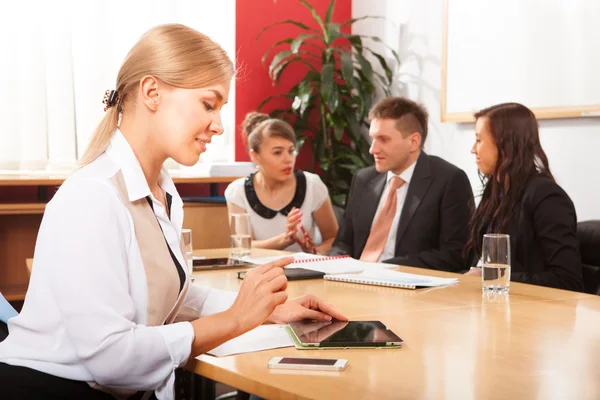 Happy businesswoman with colleagues in the background — Stock Photo, Image