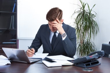 Ofiste çalışan genç bir işadamı.