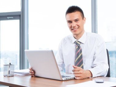 Ofiste çalışan genç bir işadamı.