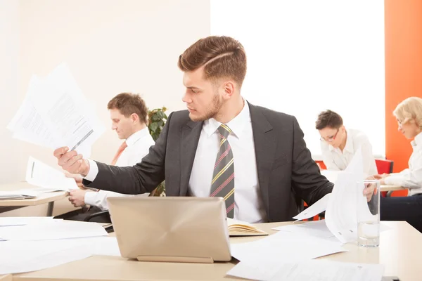 Uomo d'affari che lavora con carta e laptop — Foto Stock