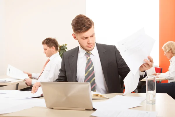 Uomo d'affari che lavora con carta e laptop — Foto Stock