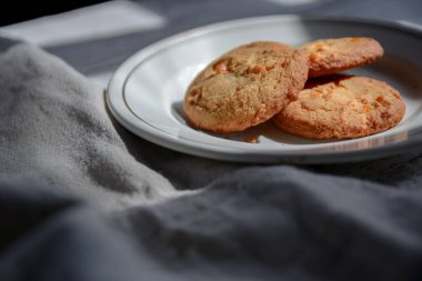 Kahvaltı için beyaz tabakta yulaflı kurabiye. Sağlıklı kahvaltı buruşuk masa örtüsü..