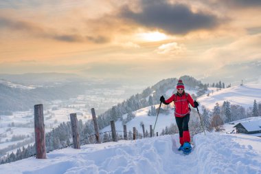 Avusturya, Vorarlberg, Bregenzerwald manzaralı Oberstaufen yakınlarındaki Allgaeu Alplerinde kar ayakkabısı giyen son sınıf öğrencisi hoş bir kadın.