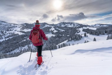 Allgau Alpleri, Bavyera, Almanya 'da kar altında kar ayakkabısı giyen güzel ve aktif bir kadın.