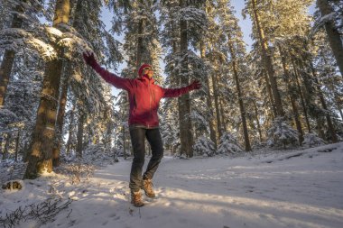 Allgaeu Alpleri, Bavyera, Almanya 'da gün batımında sakin bir kış manzarasında Neşe' den atlayan hoş bir kadın.