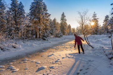 Allgaeu Alpleri, Bavyera, Almanya 'da gün batımında sakin bir kış manzarasında Neşe' den atlayan hoş bir kadın.