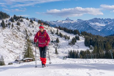 Güzel ve aktif bir kadın Allgau Alpleri, Bavyera, Almanya 'da kış yürüyüşü yapıyor.