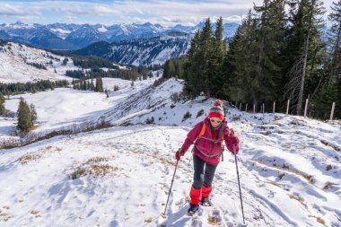 Güzel ve aktif bir kadın Allgau Alpleri, Bavyera, Almanya 'da kış yürüyüşü yapıyor.