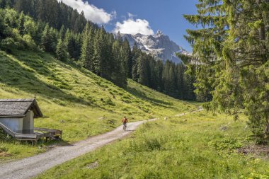 Vorarlberg Avusturya 'nın Montafon Bölgesi' ndeki Drusenfluh ve Üç Kuleleri 'nin altındaki Lindau Hut' a elektrikli dağ bisikletiyle giden yaşlı kadın.