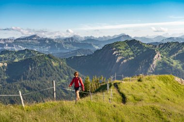 Almanya, Bavyera, Immenstadt yakınlarındaki Allgau Alpleri 'nde Nagelfluh zincirinin tepesinde sıcak şafak ışığında yürüyüş yapan son sınıf güzeli bir kadın.
