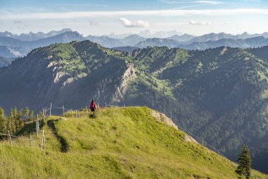 Almanya 'nın Bavyera, Immenstadt yakınlarındaki Allgau Alpleri' nde Nagelfluh zincirinin tepesinde sıcak şafak ışığında koşan aktif yaşlı kadın dağı