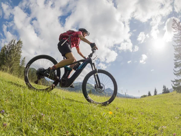 active senior woman riding her electric mountain bike in the Allgau Alps near city of Immenstadt, Algu, Bavaria, Germany