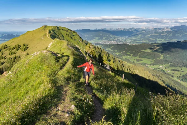 Almanya 'nın Bavyera, Immenstadt yakınlarındaki Allgau Alpleri' nde Nagelfluh zincirinin tepesinde sıcak şafak ışığında koşan aktif yaşlı kadın dağı