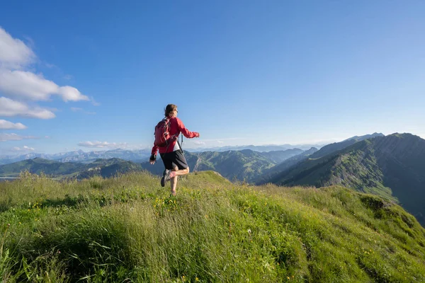 Almanya 'nın Bavyera, Immenstadt yakınlarındaki Allgau Alpleri' nde Nagelfluh zincirinin tepesinde sıcak şafak ışığında koşan aktif yaşlı kadın dağı