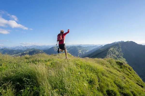 Almanya 'nın Bavyera, Immenstadt yakınlarındaki Allgau Alpleri' nde Nagelfluh zincirinin tepesinde sıcak şafak ışığında koşan aktif yaşlı kadın dağı