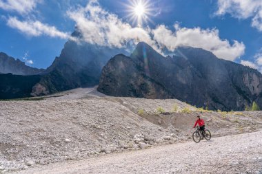 Innichen, Tre cime Ulusal Parkı, Güney Tirol, İtalya yakınlarındaki Sexten Dolomites kasabasında elektrikli dağ bisikletine binen son sınıf güzel bir kadın. 