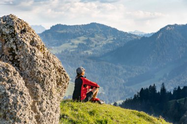 Güzel, son sınıf öğrencisi bir kadın, sıcak gün ışığında yürüyüş yapıyor ve Almanya, Bavyera, Oberstdorf yakınlarındaki Allgau Alpleri 'nin muhteşem manzarasının tadını çıkarıyor.