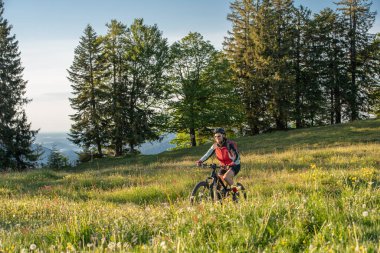 Oberstaufen, Allgau Alpleri, Bavyera Almanya 'daki dağlarda elektrikli dağ bisikleti süren güzel yaşlı kadın.