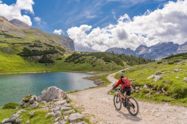 Fanes High Valley 'de, Alta Badia Dolomites, South Tirol ve Trentino, İtalya' daki Fanes-Sennes-Braies doğa parkında elektrikli dağ bisikletine binen son sınıf güzeli bir kadın.