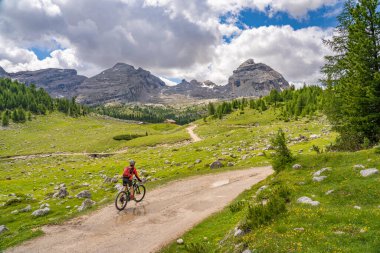 Fanes High Valley 'de, Alta Badia Dolomites, South Tirol ve Trentino, İtalya' daki Fanes-Sennes-Braies doğa parkında elektrikli dağ bisikletine binen son sınıf güzeli bir kadın.