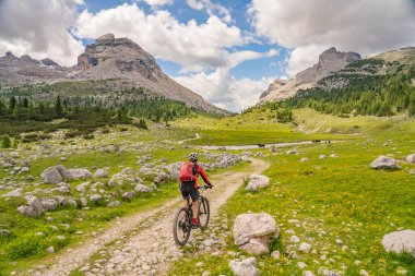 Fanes High Valley 'de, Alta Badia Dolomites, South Tirol ve Trentino, İtalya' daki Fanes-Sennes-Braies doğa parkında elektrikli dağ bisikletine binen son sınıf güzeli bir kadın.