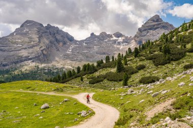 Fanes High Valley 'de, Alta Badia Dolomites, South Tirol ve Trentino, İtalya' daki Fanes-Sennes-Braies doğa parkında elektrikli dağ bisikletine binen son sınıf güzeli bir kadın.
