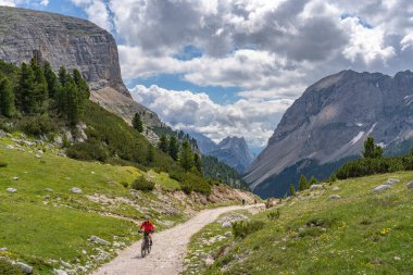 Fanes High Valley 'de, Alta Badia Dolomites, South Tirol ve Trentino, İtalya' daki Fanes-Sennes-Braies doğa parkında elektrikli dağ bisikletine binen son sınıf güzeli bir kadın.